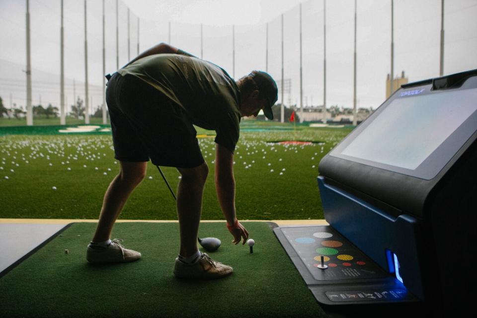 A golfer sets up his shot at Topgolf.