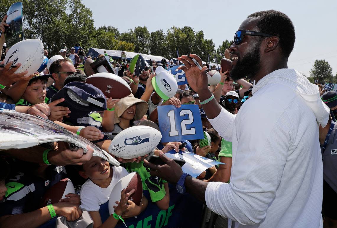 Retired Seahawks strong safety Kam Chancellor signs autographs for fans as he visits Seattle’s training camp in Renton last August. The team announced its 2019 training camp begins with a first practice on July 25.