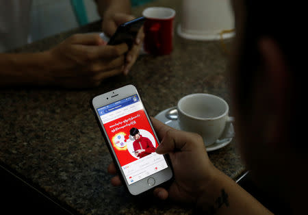 A cellphone user looks at a Facebook page at a shop in Latha street, Yangon, Myanmar August 8, 2018. REUTERS/Ann Wang