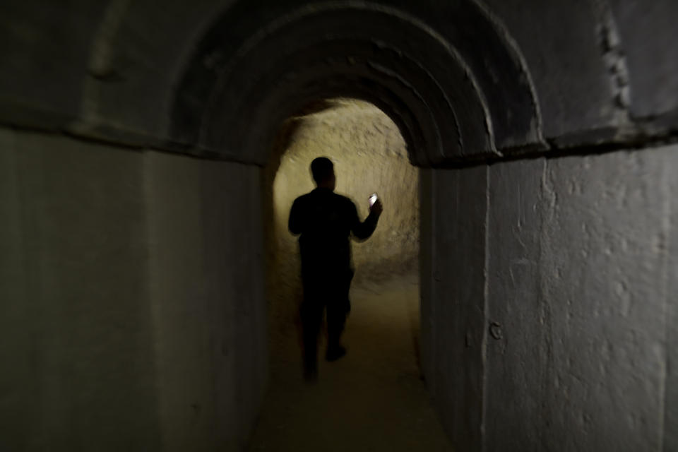 In this July 15, 2018 photo, a Syrian official walks in a tunnel leading to underground cells in the abandoned Tawbeh Prison, where over the years the Army of Islam detained hundreds of people, in Douma, near the Syrian capital Damascus, Syria. The fate of activist Razan Zaitouneh is one of the longest-running mysteries of Syria’s civil war. There’s been no sign of life, no proof of death since gunmen abducted her and three of her colleagues from her offices in the rebel-held town of Douma in 2013. Now Douma is in government hands and clues have emerged that may bring answers. (AP Photo/Hassan Ammar)