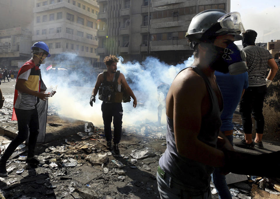 Riot police fire tear gas during clashes between Iraqi security forces and anti-government demonstrators, in downtown Baghdad, Iraq, Friday, Nov. 15, 2019. (AP Photo/Hadi Mizban)