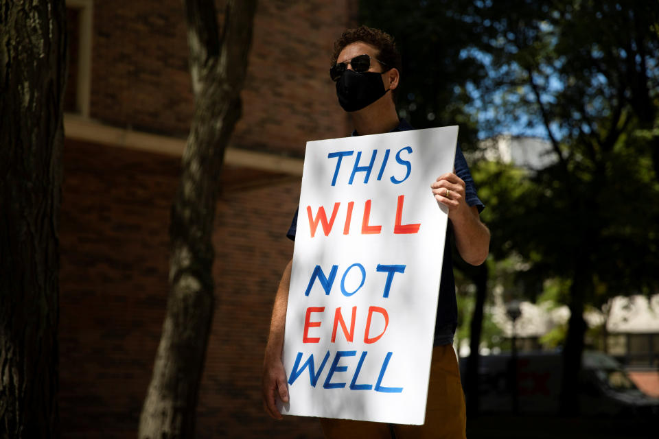 A faculty member holds a sign as students and faculty protest in-person classes for the fall semester at the University of Michigan campus in Ann Arbor in August. (Photo: Emily Elconin / Reuters)