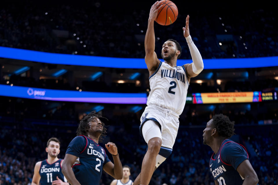 Villanova's Mark Armstrong goes up for a shot against UConn's Tristen Newton, center left, and Hassan Diarra, right, during the first half of an NCAA college basketball game Saturday, Jan. 20, 2024, in Philadelphia. (AP Photo/Chris Szagola)