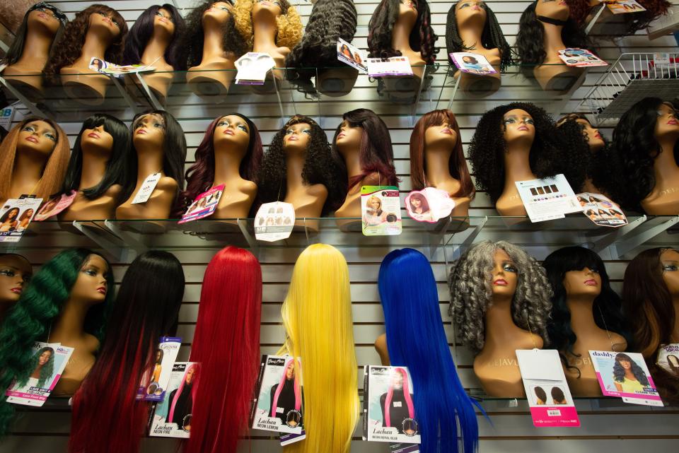 Different types of wigs, from natural colors and styles to the extravagant, fill the back wall of Biva Beauty Boutique.