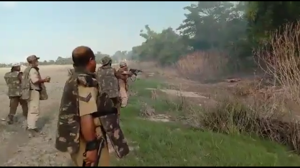 Screengrab from the video showing police in riot gear firing shots at targets from behind bushes  (Screengrab/Ahmer Khan)