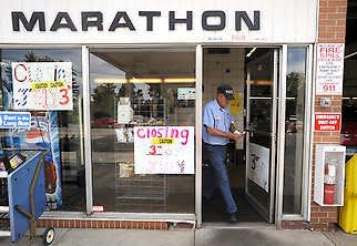 Richard “Newt” Chitwood, 74, brings hange to a customer in the full-service lane of his Marathon gas station at 17th and Madison streets. Signs on the office windows announce the station’s last day will be Thursday. The property has been sold.Chris Howell | Herald-Times