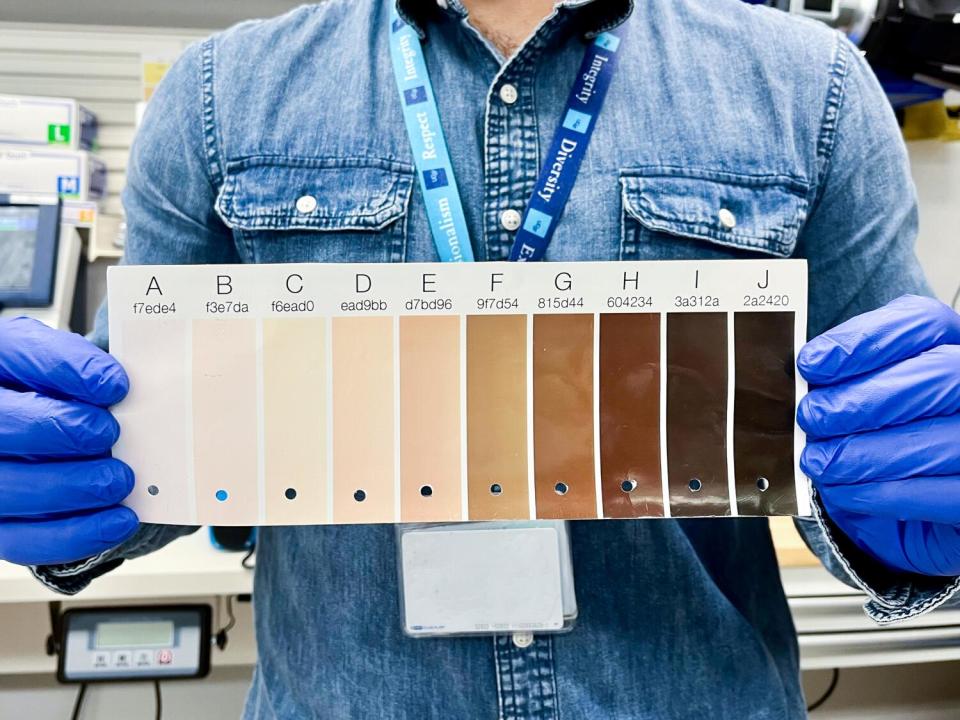 Clinical research coordinator René Vargas Zamora displays the Monk Skin Tone scale.