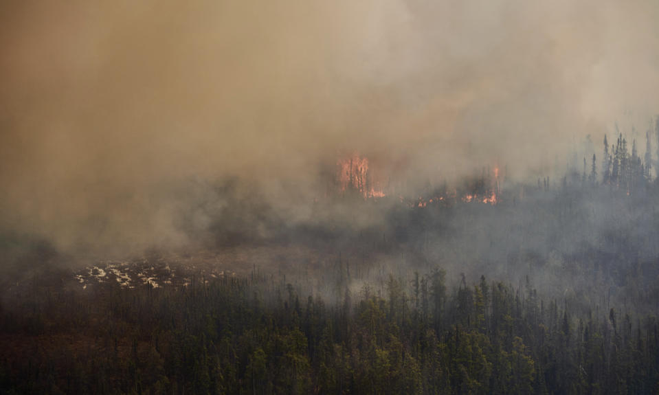 A wildfire burns in northern Manitoba near Flin Flon, as seen from a helicopter surveying the situation, Tuesday, May 14, 2024. (David Lipnowski/The Canadian Press via AP)