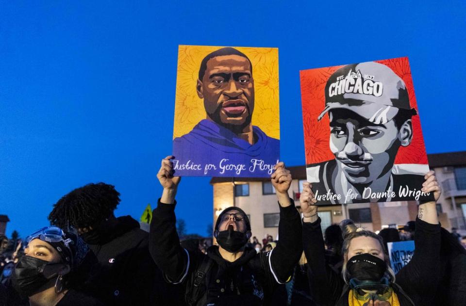 Protesters hold up sketches of George Floyd and Daunte Wright who were both killed by police officers in Minnesota (AFP via Getty Images)