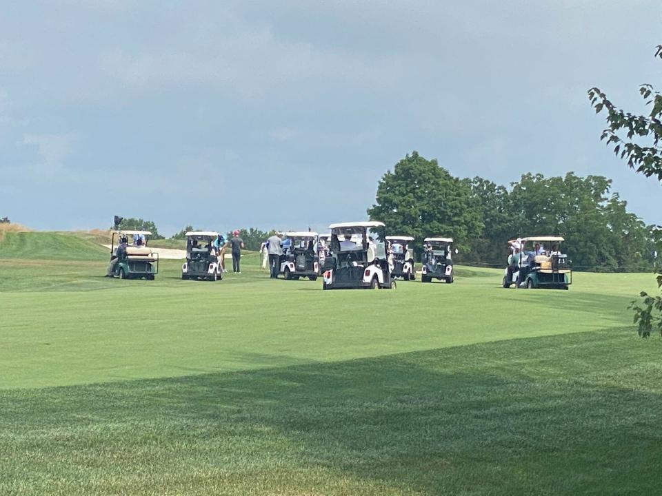 Several golf carts scramble across the fairway.