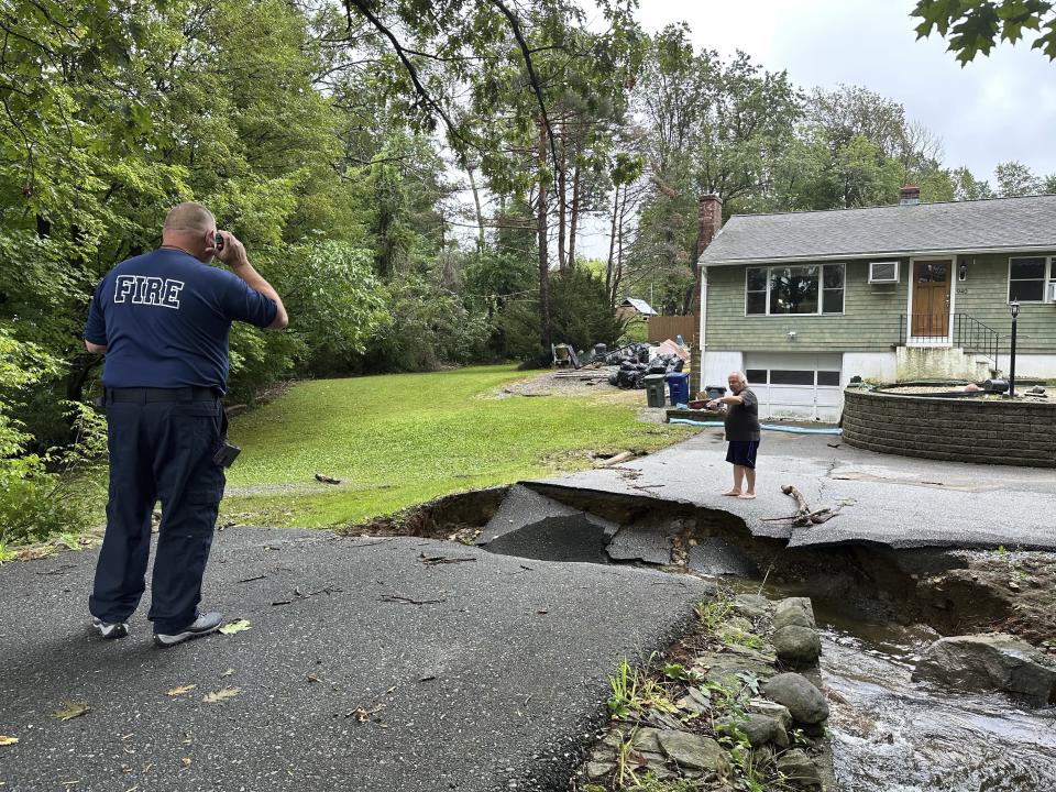 Homeowner John Schiller assesses damage to the his driveway after heavy rainfall in Leominster, Mass. and other parts of Massachusetts, Tuesday, Sept. 12, 2023. (AP Photo/Michael Casey)