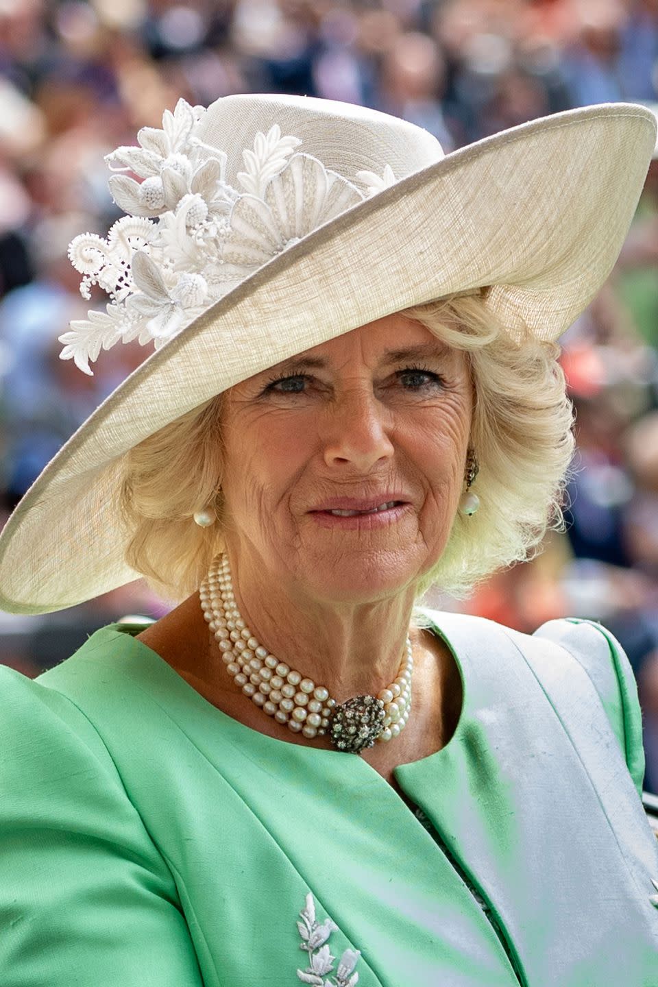 <p>Camilla, Duchess of Cornwall, opted for a green jacket and a cream linen hat embellished with fabric flowers. </p>