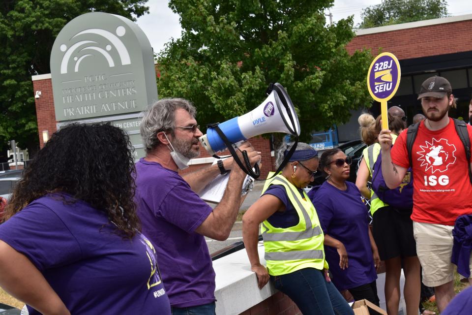 Dan Nicolai, New England district leader of SEIU, Local 32BJ, leads a rally in front of the Providence Community Health Centers complex on Prairie Avenue.