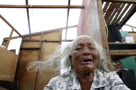 A typhoon victim takes a rest in her roofless home damaged by Typhoon Rammasun (locally named Glenda) in a coastal village of sea gypsies, also known as Badjaos, in Batangas city, south of Manila, July 17, 2014. REUTERS/Erik De Castro