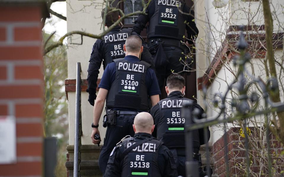 Five police officers walk into someone's home - Clemens Bilan/EPA-EFE/Shutterstock