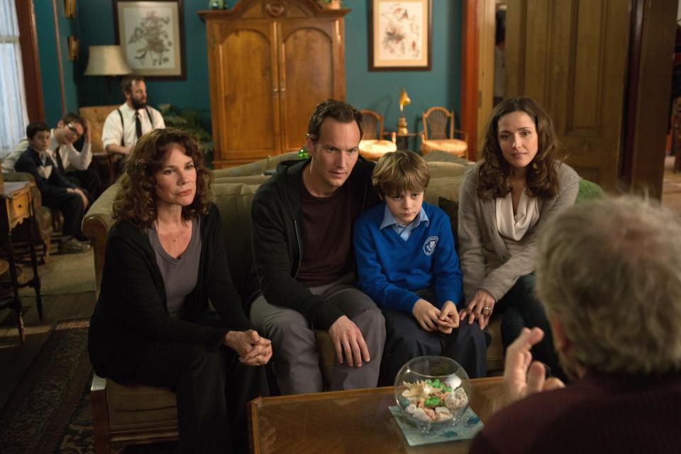 A haunted family (from left, Barbara Hershey, Patrick Wilson, Ty Simpkins and Rose Byrne) is visited by a hypnotist in "Insidious: Chapter 2."