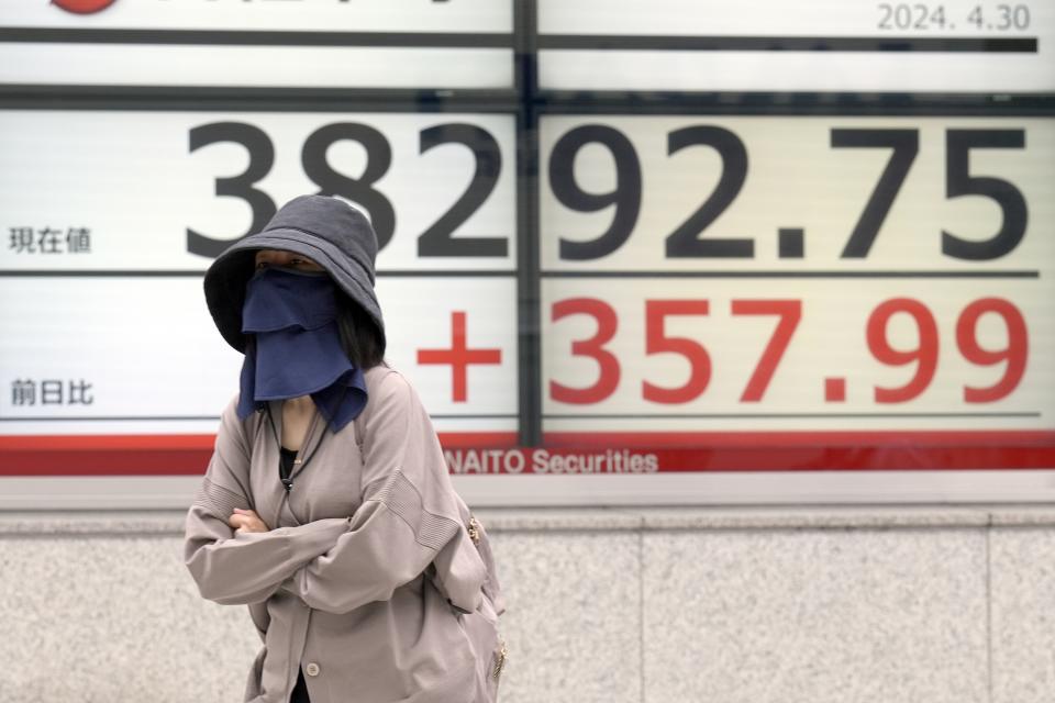 A person walks in front of an electronic stock board showing Japan's Nikkei 225 index at a securities firm Tuesday, April 30, 2024, in Tokyo. Asian shares mostly rose Tuesday, as investors kept their eyes on potentially market-moving reports expected later this week. (AP Photo/Eugene Hoshiko)