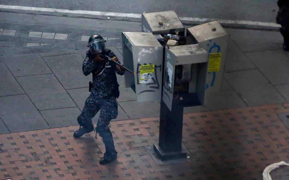 A security forces member aims his weapon after clashes broke out with opposition supporters while the Constituent Assembly election was being carried out in Caracas - Credit: Reuters