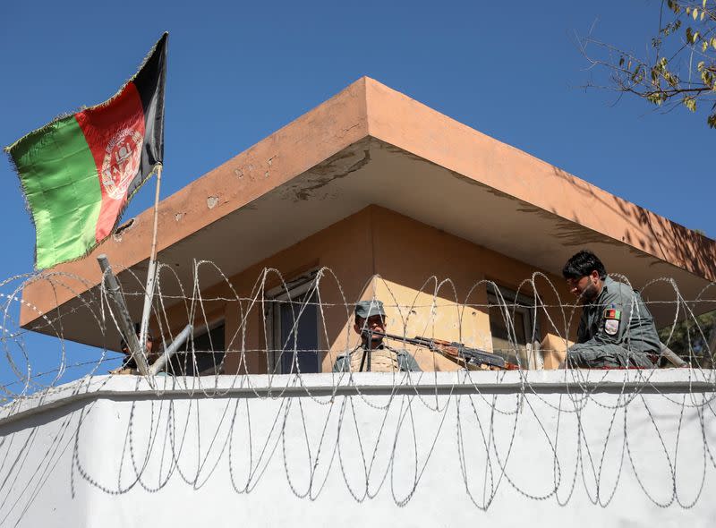 Afghan policemen keep watch near the site of an attack in Kabul