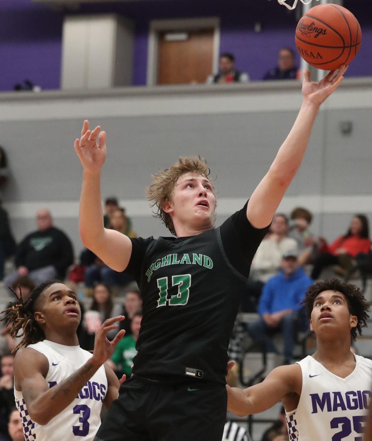 Highland's Hunter Winston goes for two as Barberton's De'Arion Holley (left) and Mike Jones (right) look on during a game Jan. 12 in Barberton. Winston is the staff ace for the Magics baseball team.