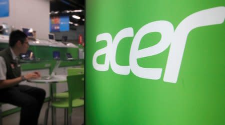 FILE PHOTO: A shop attendant sits in an Acer booth in a computer mall in Taipei, March 19, 2013.  REUTERS/Pichi Chuang/File Photo