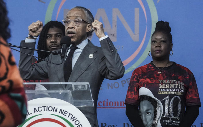 Sybrina Fulton, far right, with her son Jahvaris Fulton, left, listens as Rev. Al Sharpton, center, president of National Action Network (NAN), speaks during a rally commemorating the 10th anniversary of the killing of her son Trayvon Martin, Saturday Feb. 26, 2022, at NAN's Harlem headquarters in New York. (AP Photo/Bebeto Matthews)