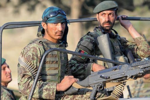 Afghan soldiers ride in a military vehicle following an attack on a hotel near Qargha lake, on outskirts of Kabul on June 22. Taliban militants armed with guns and rockets attacked a lakeside hotel near Kabul overnight, seizing dozens of hostages including women and children and killing at least 18 people