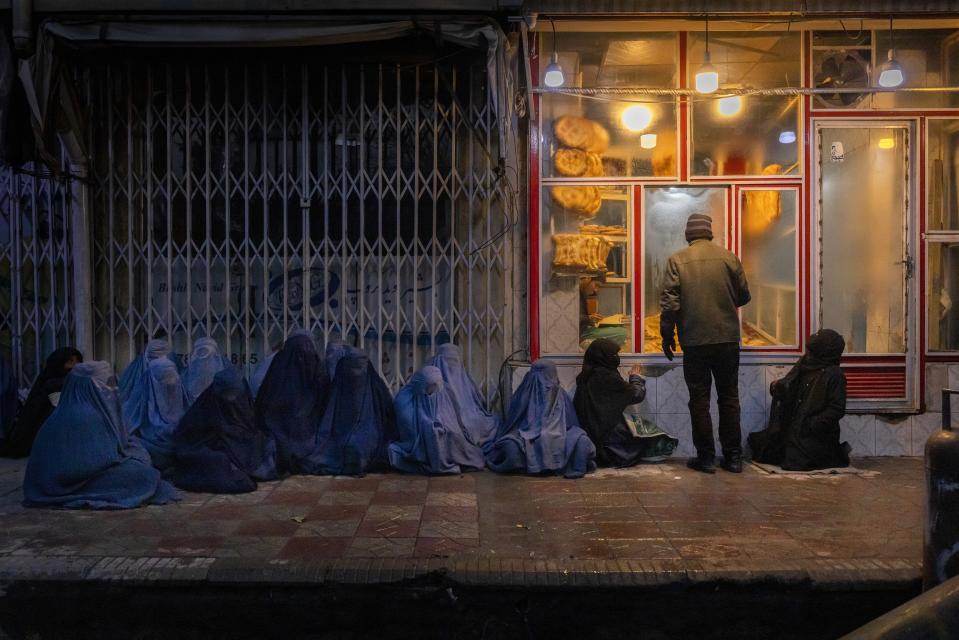 This image provided by World Press Photo is part of a series titled The Price of Peace in Afghanistan which won the World Press Photo Stories award by photographer Mads Nissen, Politiken / Panos Pictures, shows Women and children beg for bread outside a bakery in central Kabul, Afghanistan, Jan. 14, 2022. (Mads Nissen, Politiken/Panos Pictures/World Press Photo via AP)