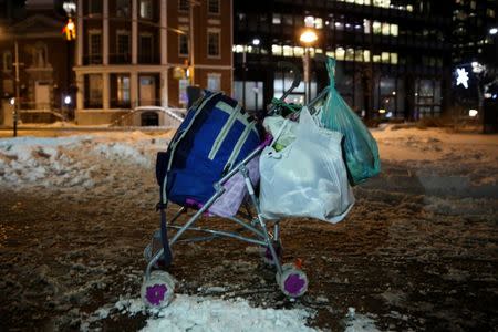 A homeless man's cart rests on the sidewalk as New York City's Coalition for the Homeless delivers food, donated clothing and supplies to homeless people as part of their weekly distribution during winter storm Grayson in Manhattan, New York City, U.S., January 4, 2018. REUTERS/Amr Alfiky