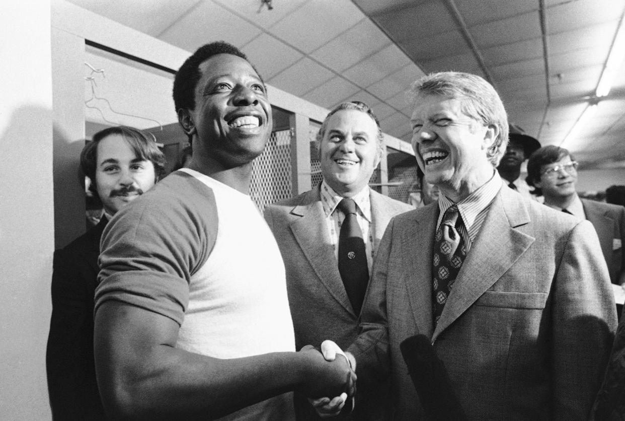 Georgia Gov. Jimmy Carter, right, and Delaware Gov. Sherman Tribbitt, center, greet Atlanta Braves Hank Aaron, left, following a canceled game due to rain, with the Los Angeles Dodgers, on Sept. 27, 1973, in Atlanta.