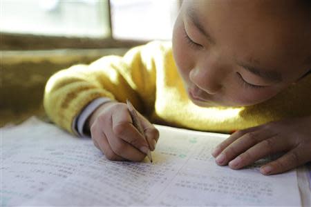 A student uses a pencil to write in class at Pengying School on the outskirts of Beijing November 11, 2013. REUTERS/Jason Lee