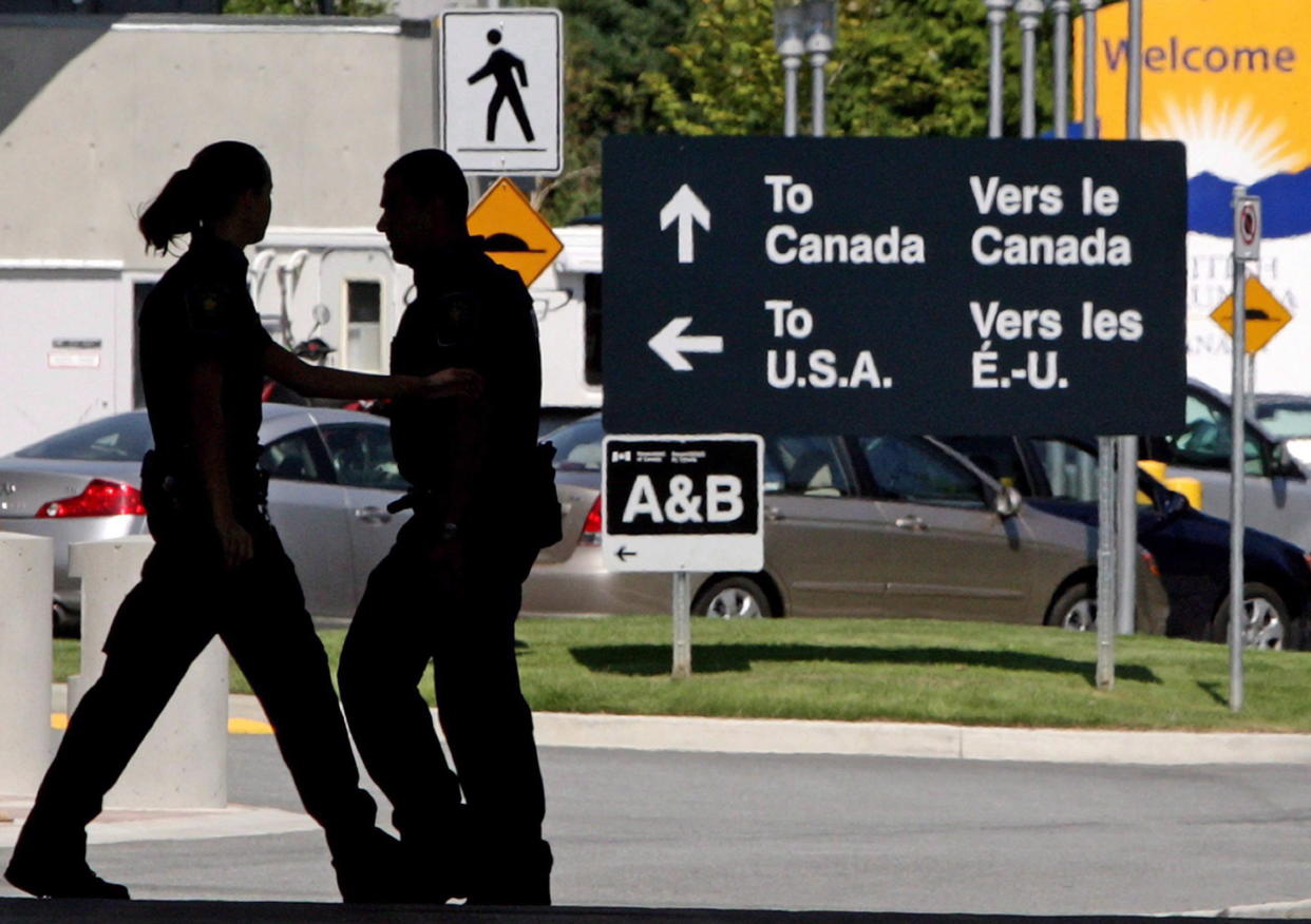 Canadian border guards are silhouetted as they replace each other at an inspection booth at the Douglas border crossing on the Canada-USA border in Surrey, B.C., on Thursday August 20, 2009. A new study commissioned by the Retail Council of Canada says an increase in the duty-free allowance for cross-border shopping would lead to hundreds of thousands of job losses and cut billions of dollars from the Canadian economy. (Photo from the Canadian Press/Darryl Dyck)