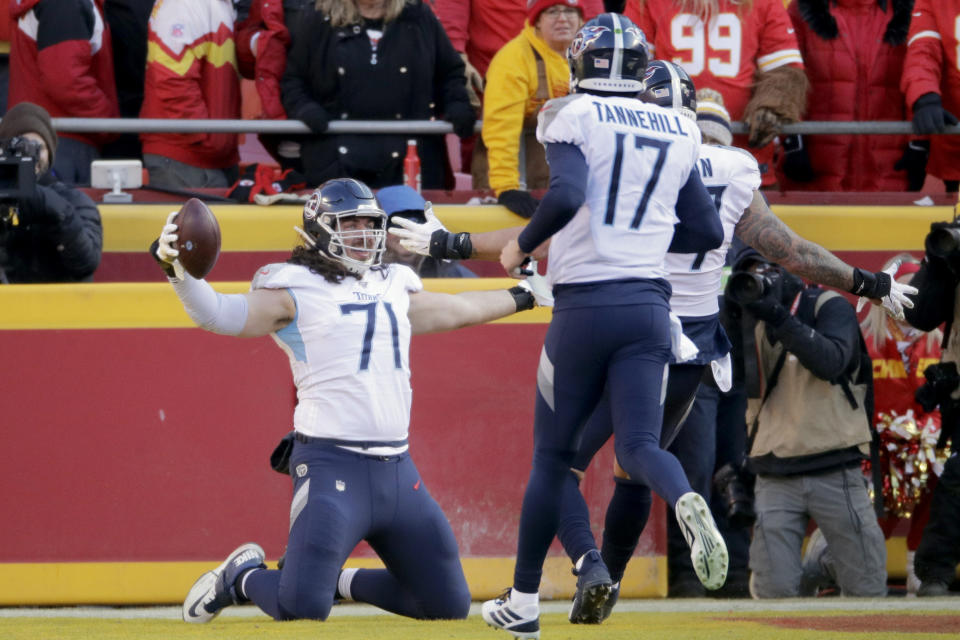 Tennessee Titans' Dennis Kelly (71) celebrates his touchdown catch with quarterback Ryan Tannehill (17) during the first half of the NFL AFC Championship football game against the Kansas City Chiefs Sunday, Jan. 19, 2020, in Kansas City, MO. (AP Photo/Charlie Riedel)