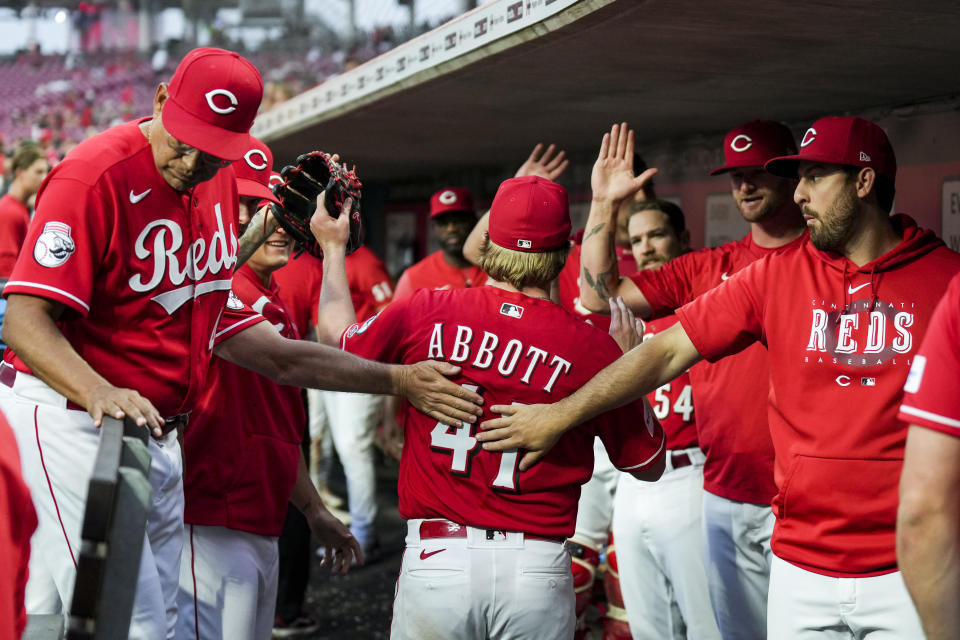 Cincinnati Reds' Andrew Abbott, center, high-fives teammates in the dugout during the sixth inning of a baseball game against the Milwaukee Brewers in Cincinnati, Monday, June 5, 2023. (AP Photo/Aaron Doster)