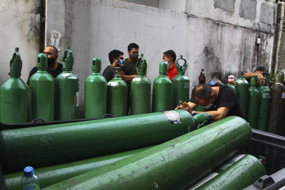 Family members of patients hospitalized with COVID-19 line up with empty oxygen tanks in an attempt to refill them, outside the Nitron da Amazonia company, in Manaus, Amazonas state, Brazil, Friday, Jan. 15, 2021. (AP Photo/Edmar Barros)