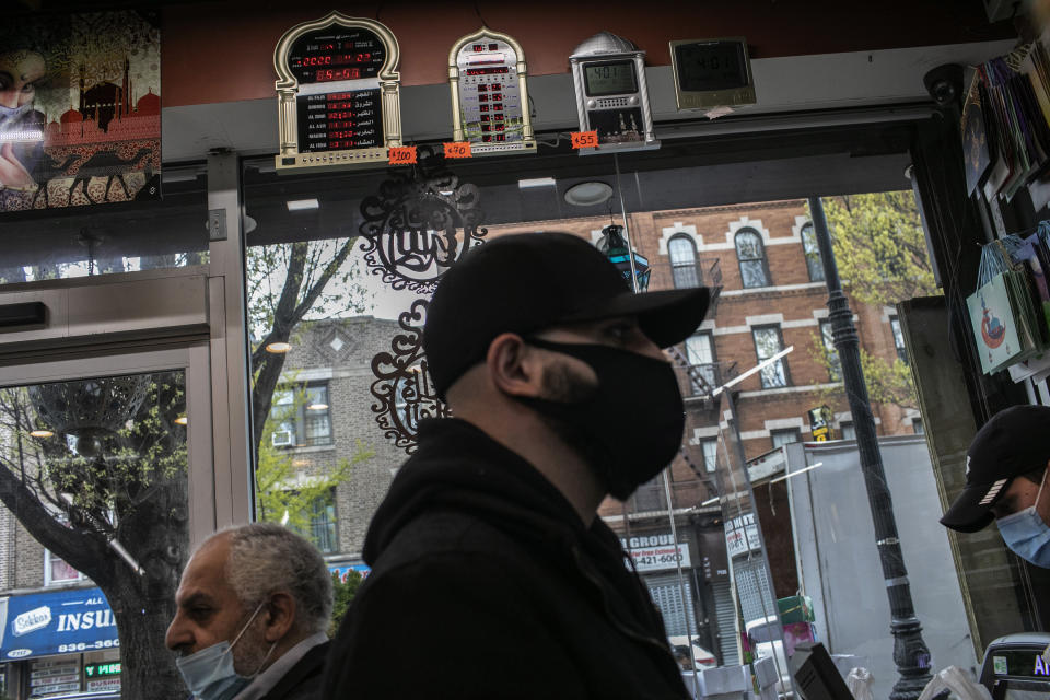 Mohammed Widdi, 31, coordinator of Muslims Giving Back waits at the cashier counter while on a grocery run for a family affected by COVID-19 in the Bay Ridge neighborhood of Brooklyn, New York, on Monday, April 27, 2020. (AP Photo/Wong Maye-E)