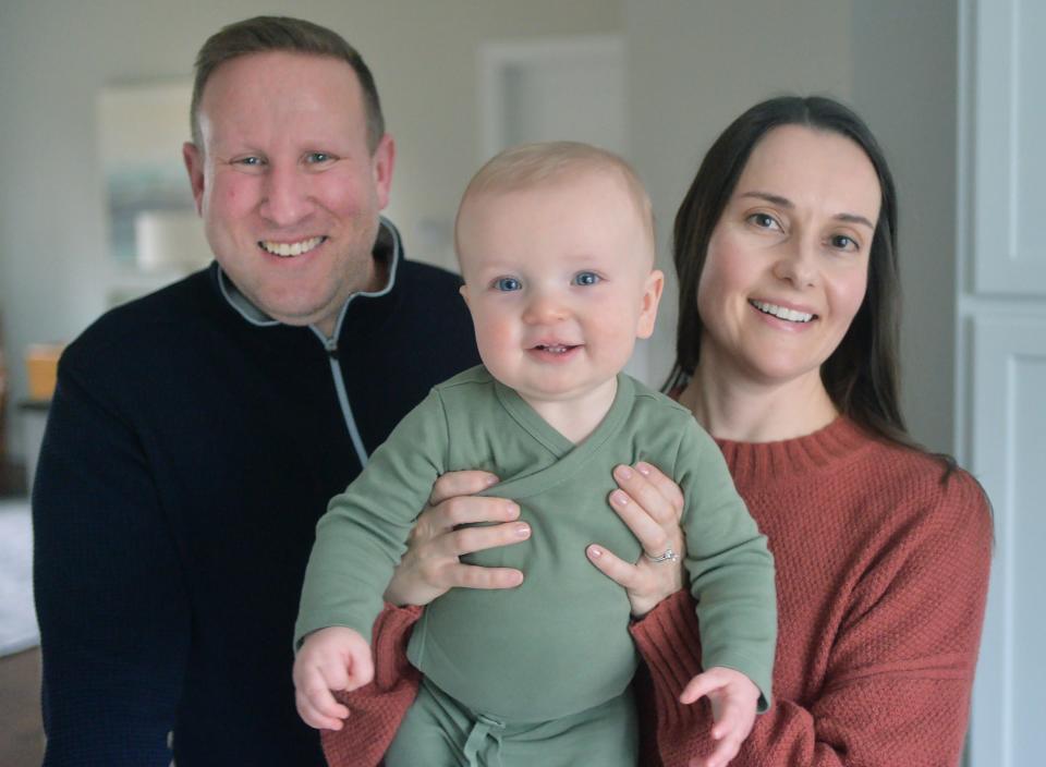 Jon Albert, 47, and his wife Stephanie Albert, 43, hold their nine-month-old son Evan at home in Fairview Township on Jan. 25, 2024. The family grew through embryonic adoption, with Stephanie carrying and giving birth to Evan.