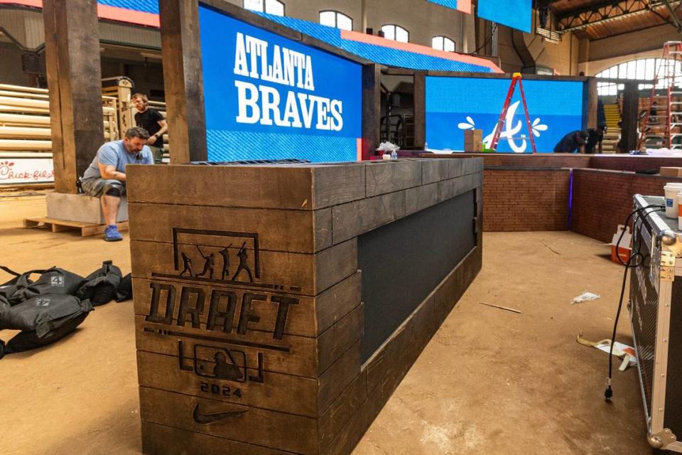 Workers construct the platform and stage area for the 2024 MLB Draft at the Cowtown Coliseum in the Fort Worth Stockyards.