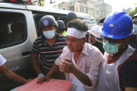 An injured protester is escorted as police tried to disperse a demonstration against the military coup in Mandalay, Myanmar, Friday, Feb. 26, 2021. (AP Photo)