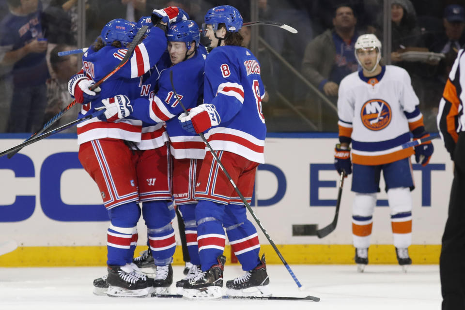 New York Rangers left wing Artemi Panarin (10) celebrates with Rangers right wing Jesper Fast (17) as Rangers defenseman Jacob Trouba (8) joins in after Fast scored against the Islanders during the first period of an NHL hockey game, Monday, Jan. 13, 2020, in New York. (AP Photo/Kathy Willens)
