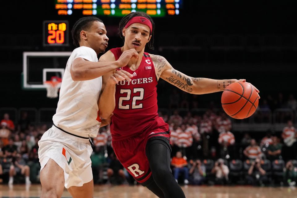 Rutgers Scarlet Knights guard Caleb McConnell (22) drives the. all around Miami Hurricanes guard Isaiah Wong (2) during the first half at Watsco Center.