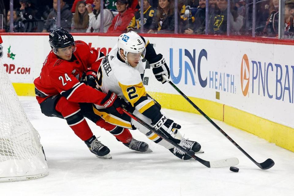 Carolina Hurricanes’ Seth Jarvis (24) battles Pittsburgh Penguins’ Chad Ruhwedel (2) during the second period of an NHL hockey game in Raleigh, N.C., Sunday, Dec. 18, 2022. (AP Photo/Karl B DeBlaker)