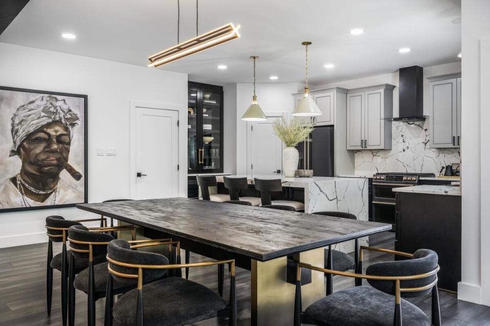 A luxurious black-and-white kitchen features subtle brass accents