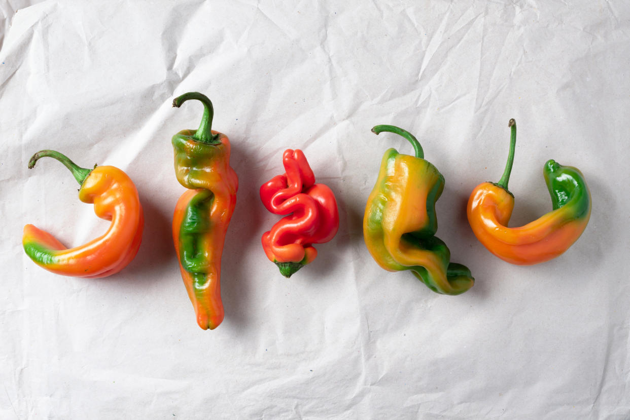 Ugly bell pepper on craft paper background. Concept of zero waste production. Top view. Copy space. Non gmo vegetables.