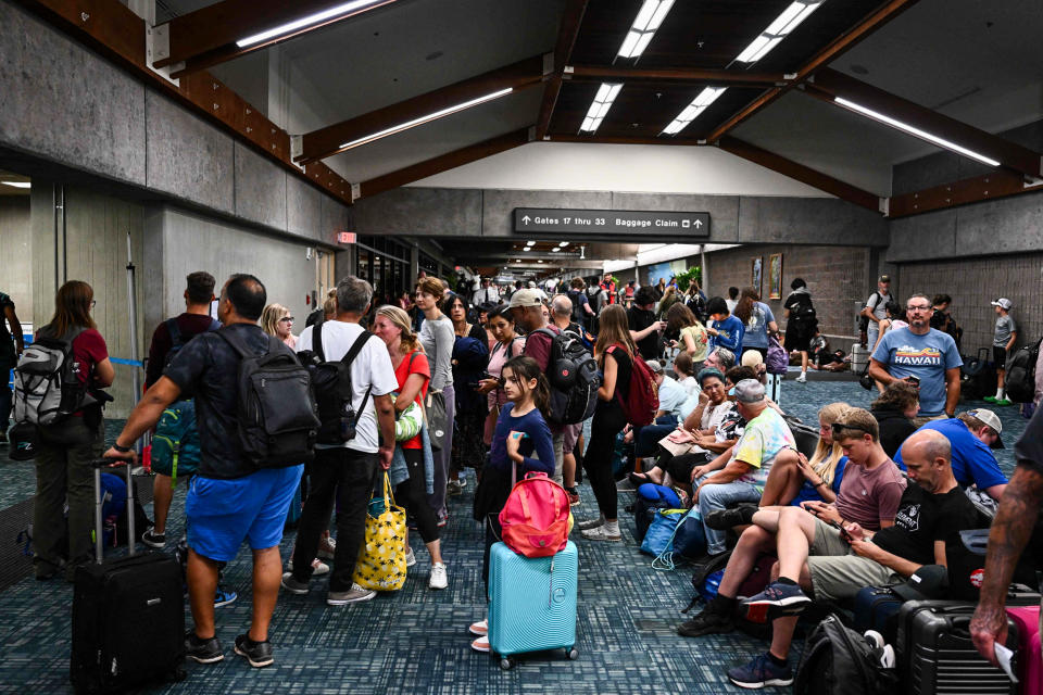 Passengers try to rest and sleep after canceled and delayed flights while others wait to board flights off the island as thousands of passengers were stranded at the Kahului Airport in Kahului, Hawaii, on Aug. 9, 2023. (Patrick T. Fallon / AFP - Getty Images)