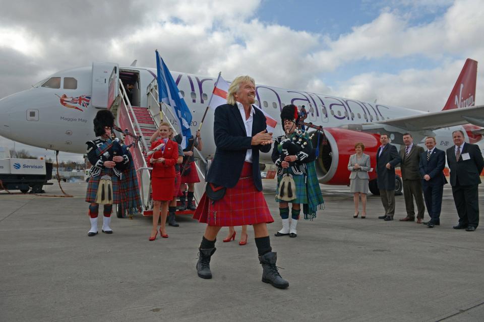 Sir Richard Branson arrives at Edinburgh Airport in a Virgin Atlantic Airways Airbus A320 wearing a Harris Tweed Kilt in 2013.