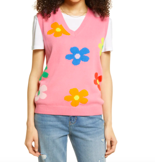 Model wears Be Proud Daisy Gender Inclusive Sweater Vest in pick flower print