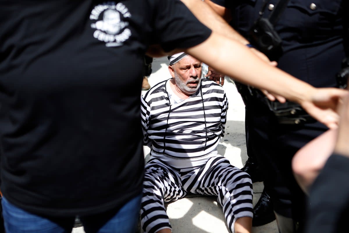 Dominic Santana of Miami is detained by Miami police after trying to block former President Donald Trump's motorcade (Getty Images)