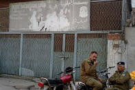 Police officers stand guard outside a morgue where the body of a Sri Lankan citizen who was lynched by Muslim mob, is kept, in Sialkot, Pakistan, Friday, Dec. 3, 2021. A Muslim mob attacked a sports equipment factory in Pakistan's eastern Punjab province on Friday, killing a Sri Lankan over allegations of blasphemy, police said. (AP Photo/Shahid Akram)