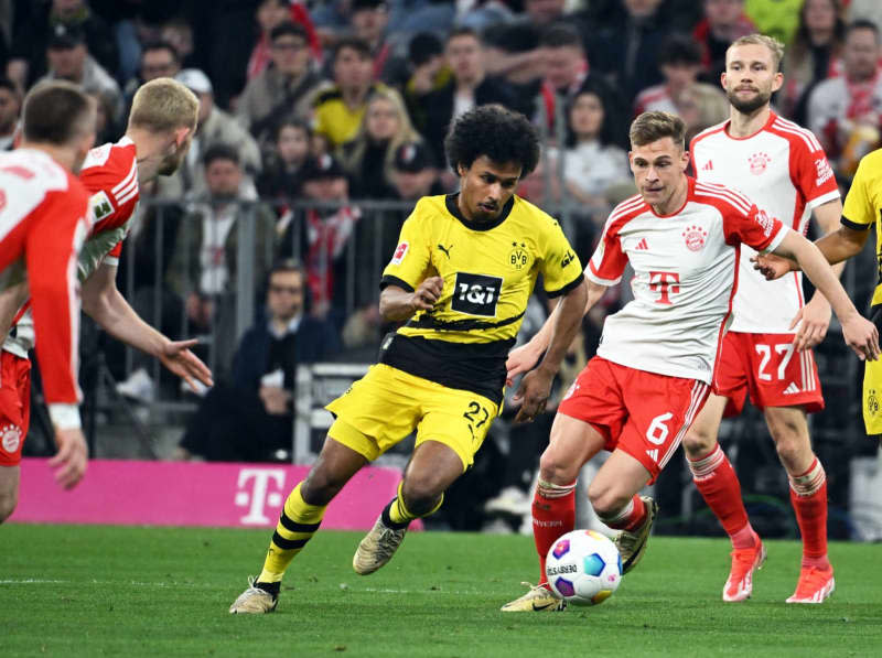 Dortmund's Karim Adeyemi (L) and Bayern's Joshua Kimmich action during German Bundesliga soccer match between Bayern Munich and Borussia Dortmund at the Allianz Arena. Sven Hoppe/dpa